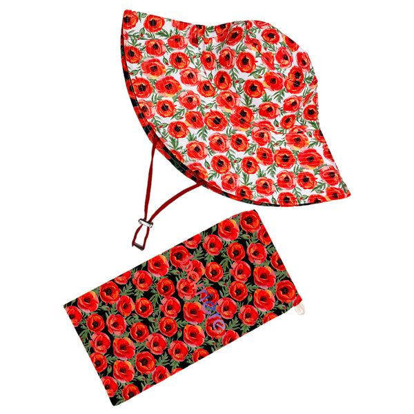 A sun hat and a pouch with a matching red floral pattern on a white background. The sun hat has a wide brim and is equipped with an adjustable toggle on a red cord to secure it under the chin. Both items feature vibrant red flowers with green leaves, creating an eye-catching and coordinated set.